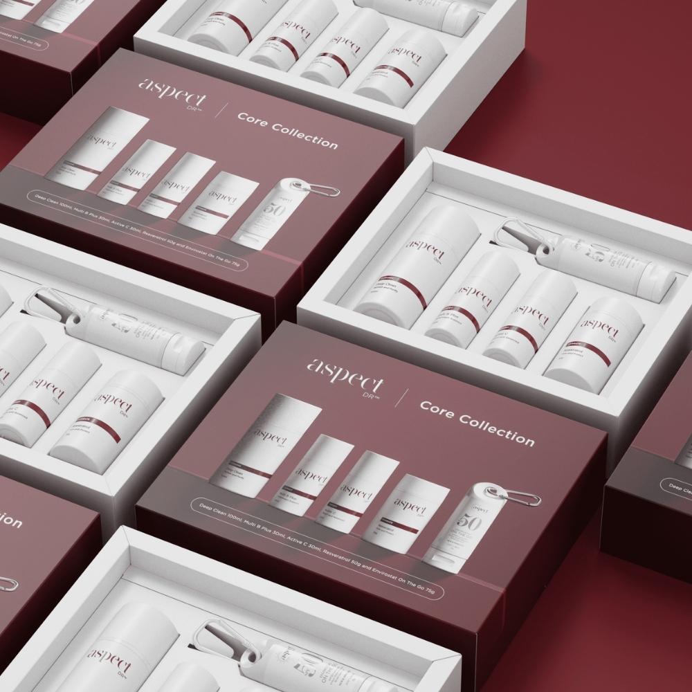 aspect dr skincare product core collection with maroon and white packaging on a red background